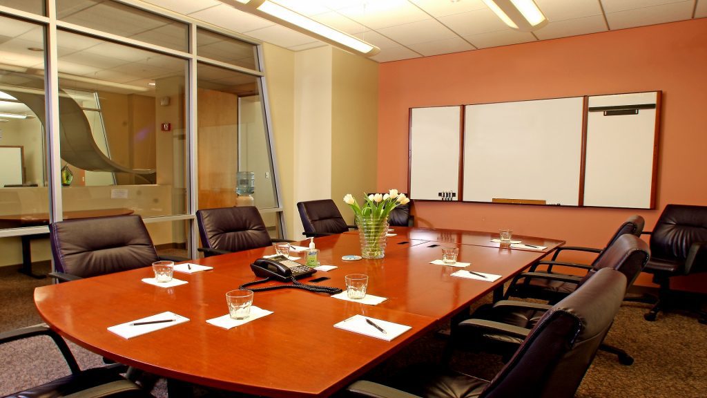 Conference room with large table, chairs and whiteboard