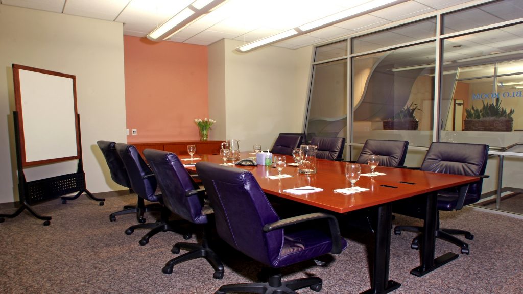 Conference room with large table, chairs and whiteboard