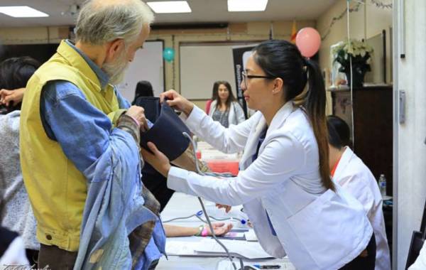 Woman taking the blood pressure of an older man